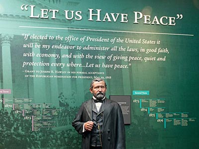 Lifelike statue of Ulysses S. Grant in front of a wall reading Let us Have Peace.